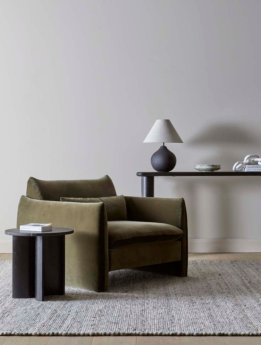 Sidney Peak 1 Seater Sofa in Caper Velvet, styled in a living room beside a timber side table