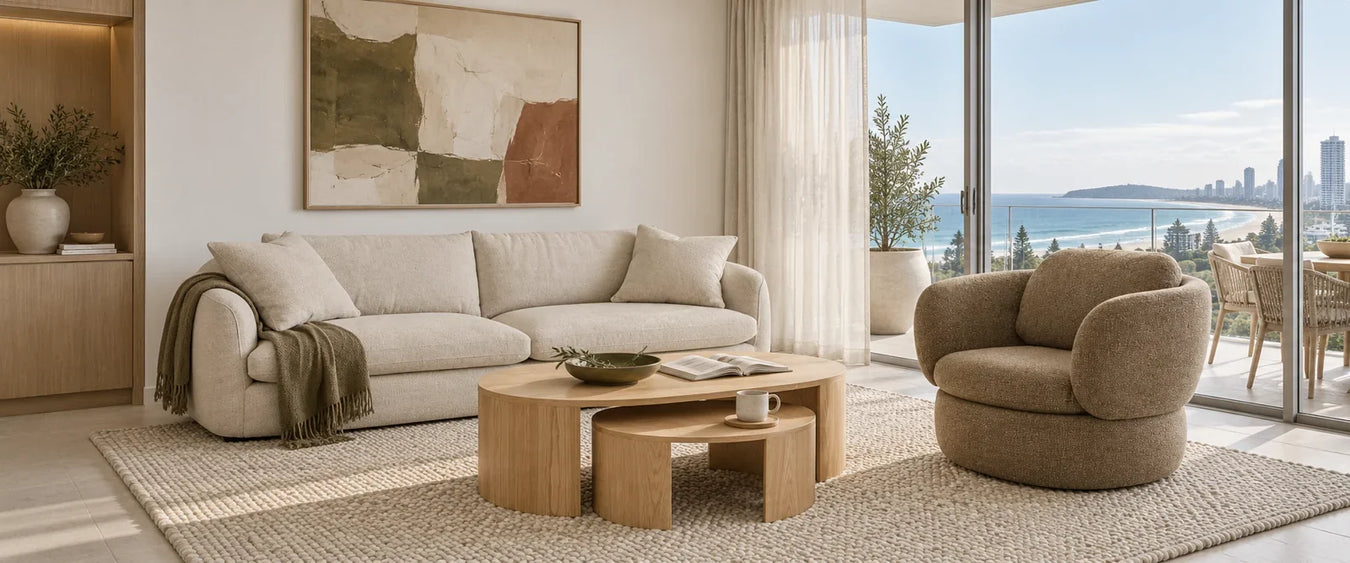 Cream sofa, ash nesting tables and a toffee armchair on an oat rug overlooking the Gold Coast