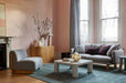 Tepih Dune Rug in Sacramento, styled in a living room with a grey sofa and pale coffee table against pink walls