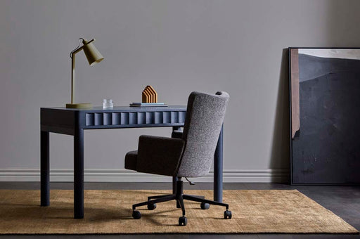 Tepih Dune Rug in Olive, in a study under a navy desk and a grey office chair