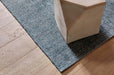 Tepih Dune Rug in Sacramento, a corner on timber floorboards beside a stone side table