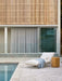 Seville Tiled Side Table in honey beside a white sun lounger on a poolside terrace