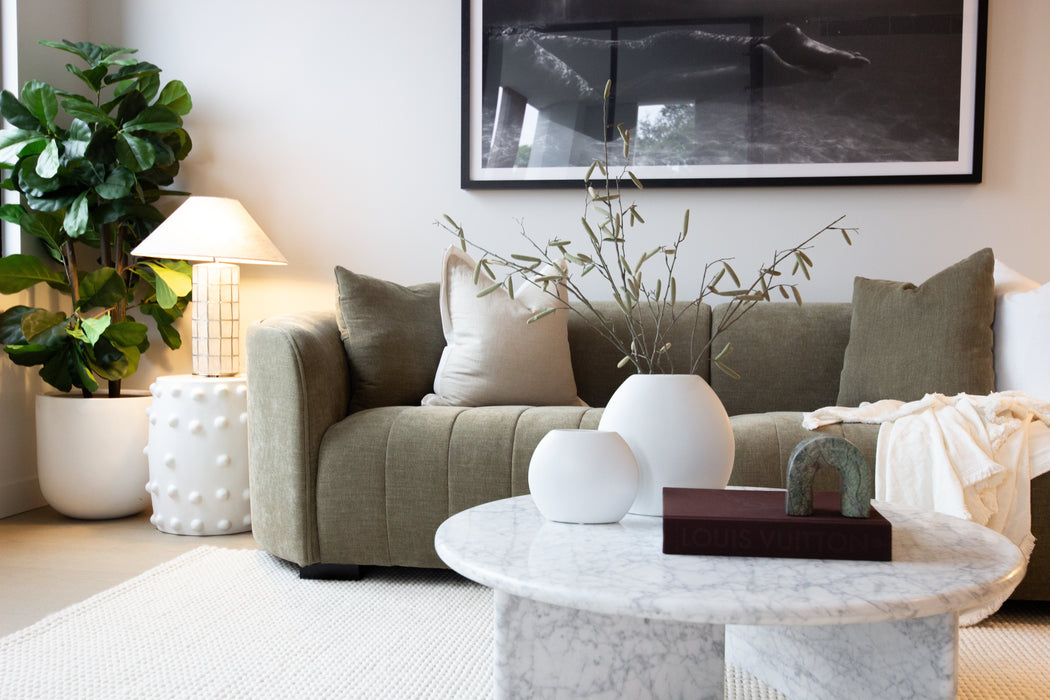 Juniper Pearl Sofa - Copeland Olive, styled in a living room with a marble coffee table