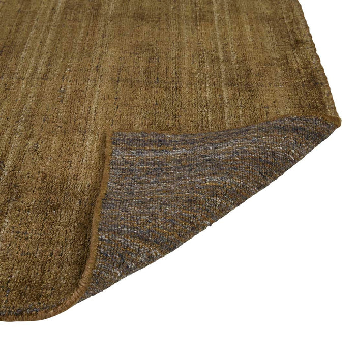 Tepih Dune Rug in Olive, a corner folded back to show the woven underside