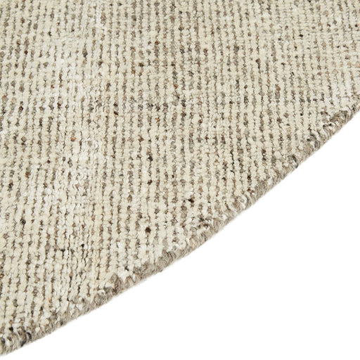 Tepih Dune Round Rug in Oatmeal, close-up of the curved edge and flecked weave