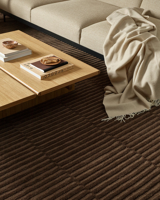 Anni Floor Rug in Chocolate, beside a cream sofa and timber coffee table with a draped wool throw