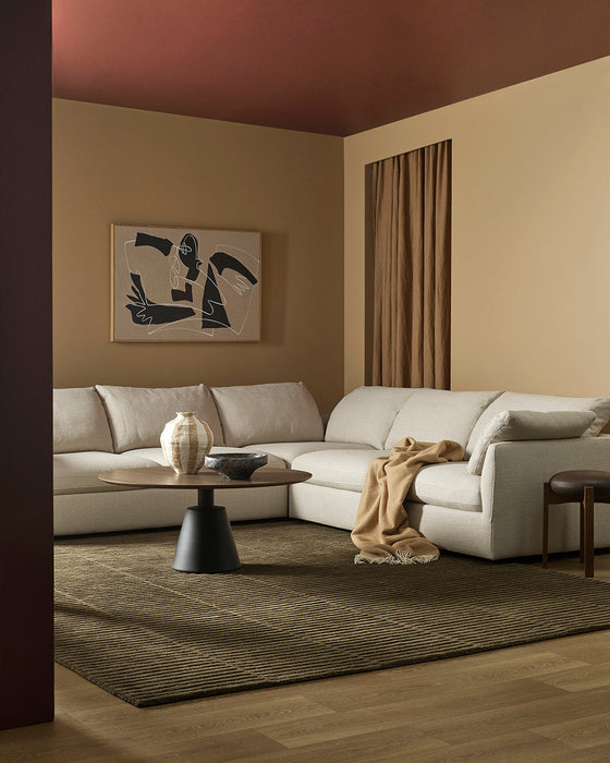 Anni Floor Rug in Mangrove, styled in a living room with a cream modular sofa and round black coffee table