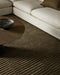 Anni Floor Rug in Mangrove, under a round timber coffee table beside a cream sofa, showing the ribbed pile