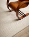 Anni Floor Rug in Oat, close up with a bentwood lounge chair, showing the ribbed pattern