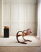 Anni Floor Rug in Oat, in a panelled room with a bentwood lounge chair and black side table