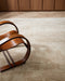 Beckett Floor Rug in Straw, with a bentwood timber armchair on a herringbone floor