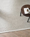 Clifton Floor Rug in Bone, seen from above beside a dark timber stool with books