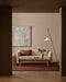 Bastion Floor Rug in Claret, styled in a living room with a cream sofa, timber coffee table and floor lamp