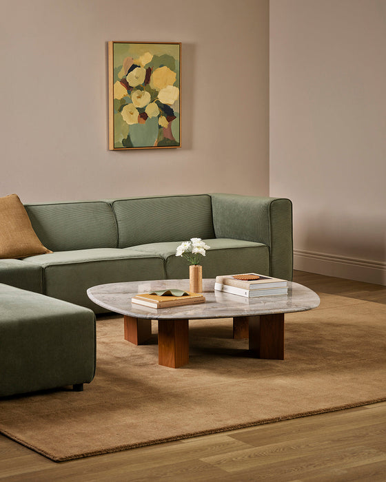 Bastion Floor Rug in Hazelnut, styled in a living room with a green modular sofa and marble coffee table