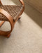 Kansas Floor Rug in Oat/Natural, close view beside a woven armchair with a bentwood frame
