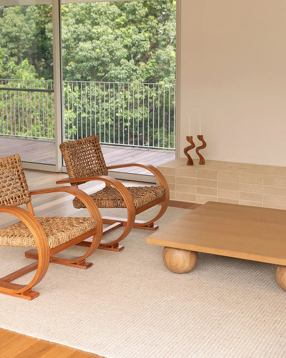 Kansas Floor Rug in Oat/Natural, in a sunlit living room with woven armchairs and a low timber table
