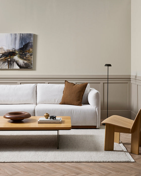 Clifton Floor Rug in Bone, styled in a living room with a white sofa, timber coffee table and lounge chair