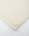 Clifton Floor Rug in Ivory, close-up of a corner showing the edge and wool pile