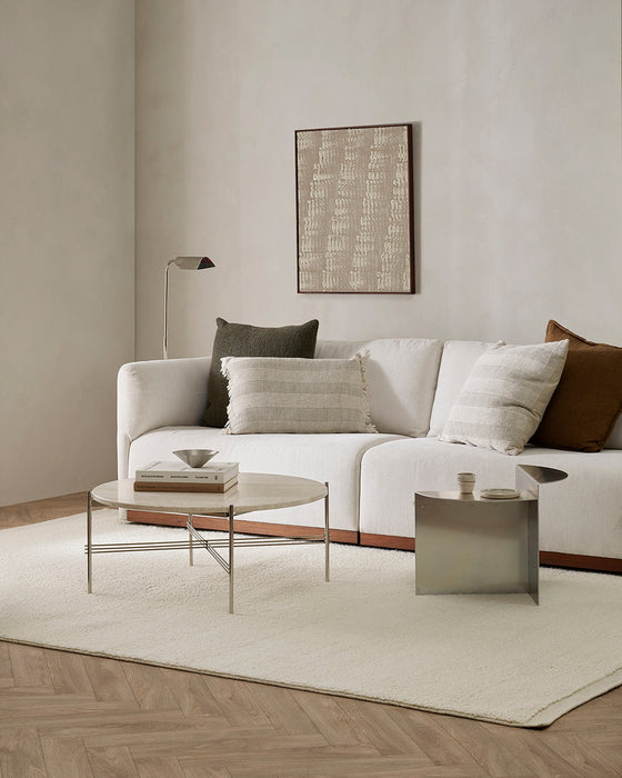 Clifton Floor Rug in Ivory, under a white sofa, round coffee table and metal side table