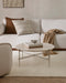 Clifton Floor Rug in Ivory, under a round stone coffee table beside a white sofa with cushions