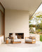 Palm Cove Round Floor Rug in Sand, on a covered terrace with two teak armchairs beside an outdoor fireplace