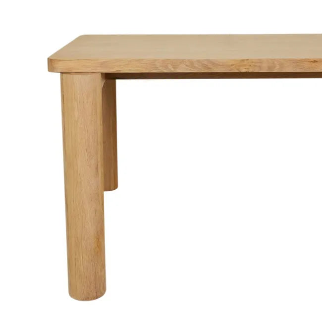 Close-up of a round oak leg and the tabletop corner of the Flint Dining Table