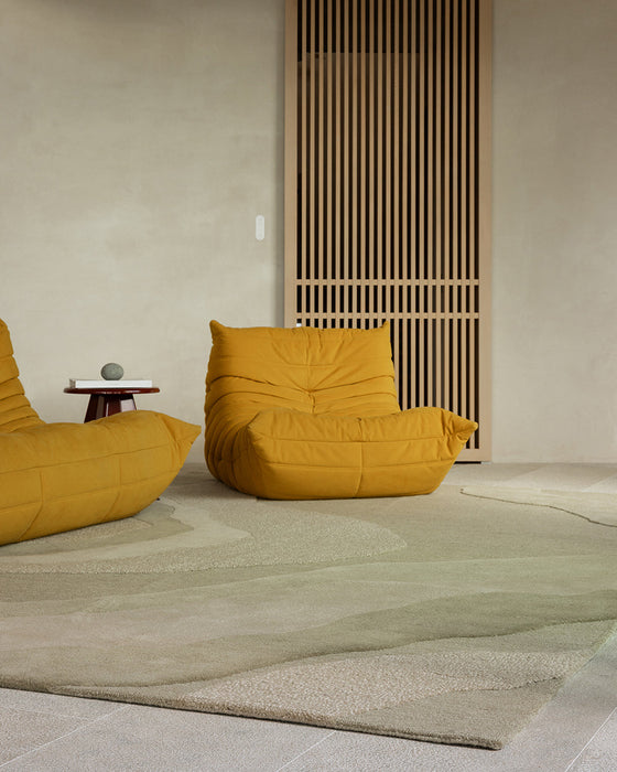 Edgewater Floor Rug in Pistachio, in a living room with mustard lounge chairs and timber slat screen