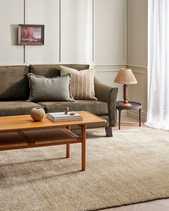 Fairbanks Floor Rug in Limestone, under a timber coffee table and olive sofa with a table lamp