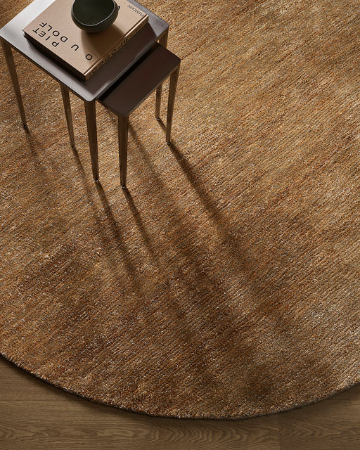 Fairbanks Round Floor Rug in Sand, seen from above with nesting side tables, showing the pile texture