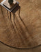 Fairbanks Round Floor Rug in Sand, seen from above with nesting side tables, showing the pile texture