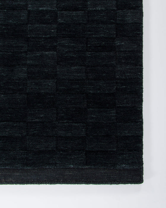 Hugo Floor Rug in Midnight, close-up of a corner showing the edge and wool pile