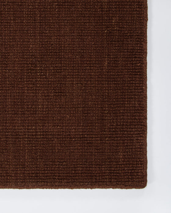 Linden Floor Rug in Brick, close-up of a corner showing the edge and wool pile