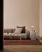 Linden Floor Rug in Brick, in a living room with a pink sofa, striped cushions and timber coffee table