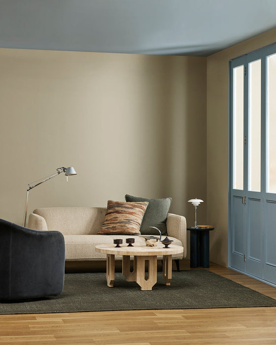 Linden Floor Rug in Petrol, in a living room with a cream sofa, sculptural coffee table and floor lamp
