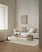 Clifton Floor Rug in Ivory, styled in a living room with a white sofa and round glass coffee table