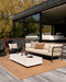 Lonsdale Floor Rug in Cumin, on a timber deck with an outdoor sofa and white coffee table