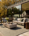 Lonsdale Floor Rug in Eucalyptus, on a timber deck with an outdoor sofa and concrete coffee table