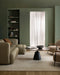 Mayfair Floor Rug in Abalone, in a green-walled living room with a boucle sofa and round black coffee table
