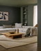 Mayfair Floor Rug in Wheat, in a green-walled living room with a cream sectional and timber coffee table