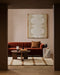 Mesa Floor Rug in Camel, in a living room with a rust velvet sofa and round timber coffee table