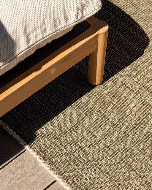 Lonsdale Floor Rug in Olive, close view under an outdoor timber sofa, showing the weave