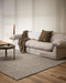 Nebraska Floor Rug in Ash, in a living room with a linen sofa and round dark side table