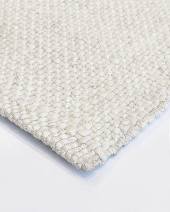 Nebraska Floor Rug in Natural White, close-up of a corner showing the edge and wool and viscose pile