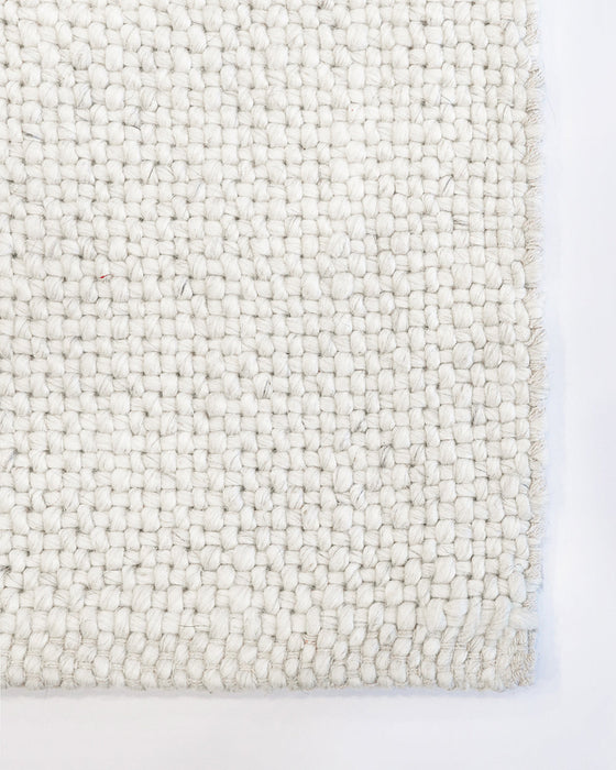 Nebraska Floor Rug in Natural White, close-up of a corner showing the edge and wool and viscose pile