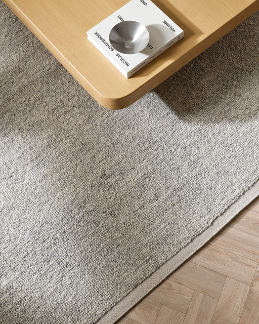 Clifton Floor Rug in Ash, close up under a pale timber coffee table, showing the looped pile