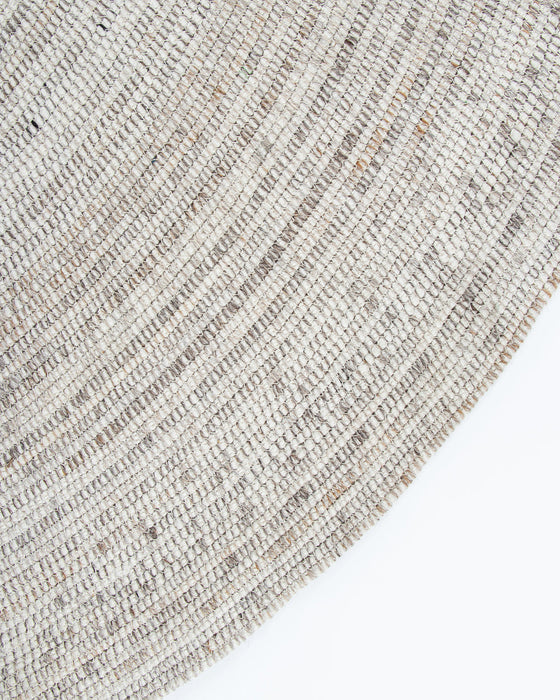 Palm Cove Round Floor Rug in Sand, close-up of the curved edge and recycled PET weave