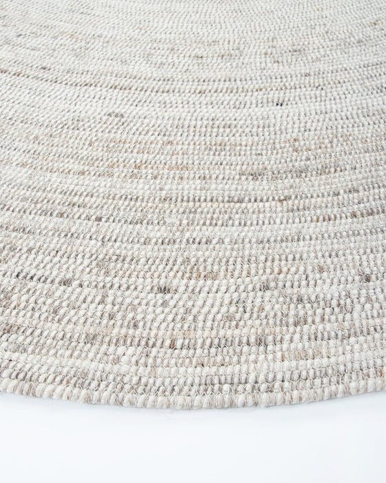 Palm Cove Round Floor Rug in Sand, close-up of the curved edge and recycled PET weave