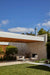 Terrace and lawn beneath a flat roofline, with Blossom armchairs by the outdoor fireplace