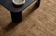 Tepih Dune Rug in Olive, seen from above under a black fluted side table