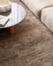 Fairbanks Floor Rug in Fossil, seen from above beside a stone coffee table and cream sofa